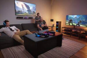 A split-screen view showcasing a sleek gaming console setup on the left with a large TV and controller, and a high-performance gaming PC on the right with a multi-monitor display and mechanical keyboard.